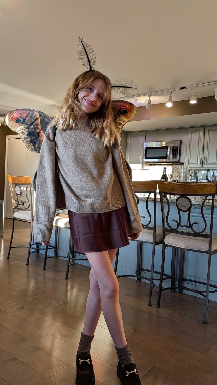 In a sun-warmed kitchen that doubles as a studio, imagination takes flight—feathered antennae tilt toward the light while painted wings catch the hush of an ordinary afternoon turned magical. Between barstools and countertops, play becomes art, a quiet rehearsal where creativity tries on costumes and grins at its own reflection. The mood is tender and buoyant, as if the room itself is holding its breath, ready to lift off.